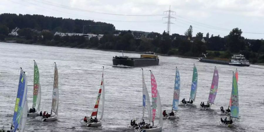 Segelboote starten auf dem Rhein zur weltweit ersten Kulturregatta. Foto: Roberto Pfeil/dpa