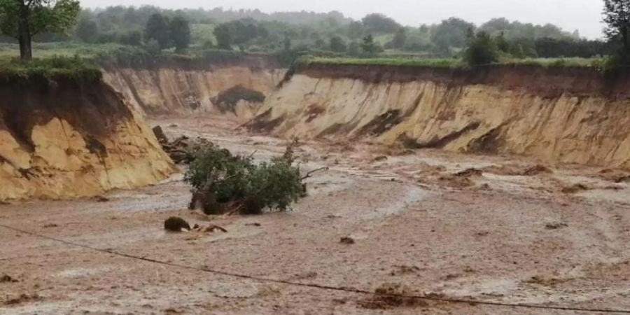 Der vor einigen Jahren wegen des Tagebaus umgelegte Fluss Inde hat sich nach schweren Regenfällen ein neues Bett gegraben und strömt unkontrolliert in den Braunkohle-Tagebau Inden. ). Foto: Olaf Rossbroich/dpa