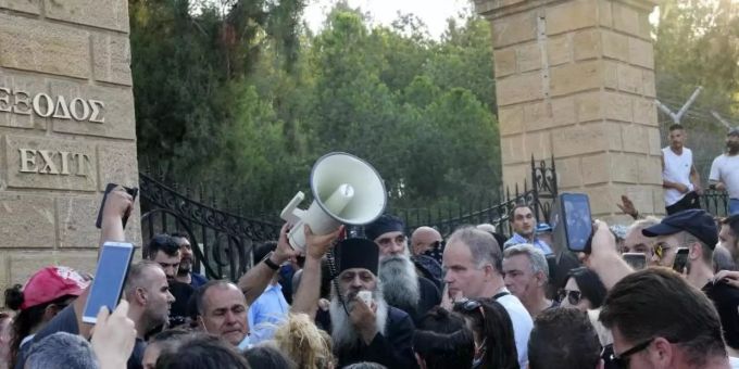 Ein griechisch-orthodoxer Priester spricht zu Demonstranten während des Protests gegen die Corona-Massnahmen vor dem Präsidentenpalast. Foto: Petros Karadjias/AP/dpa Ein griechisch-orthodoxer Priester spricht zu Demonstranten während des Protests gegen die Corona-Massnahmen vor dem Präsidentenpalast. Foto: Petros Karadjias/AP/dpa