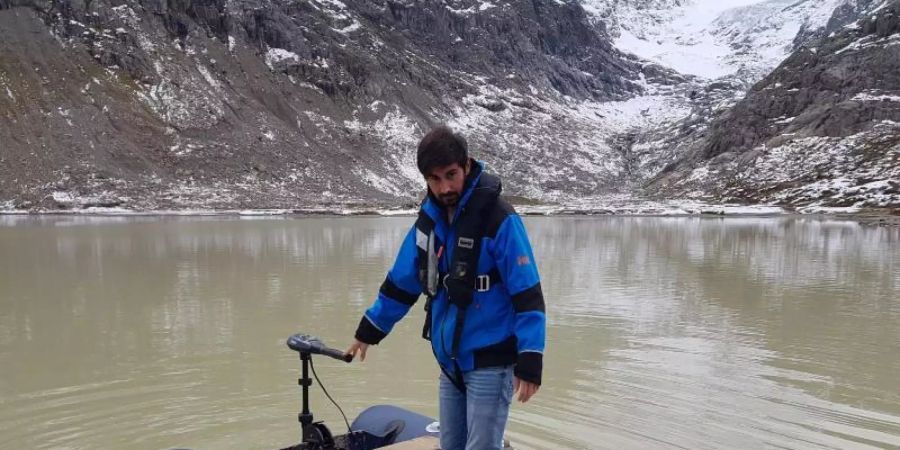 Michael Plüss, Techniker der Eawag-Abteilung Oberflächengewässer, installiert eine Thermistorenkette auf dem Steisee. Foto: Nico Moelg/Eawag/dpa