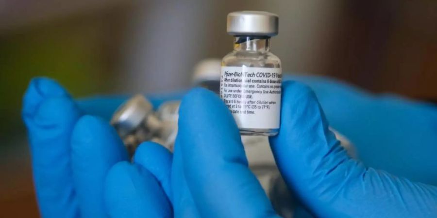 Ein Impfarzt hält einen Behälter mit dem Impfstoff gegen Covid-19 von Pfizer in einem Impfzentrum während der Impfung. Foto: Dinendra Haria/SOPA Images via ZUMA Press Wire/dpa