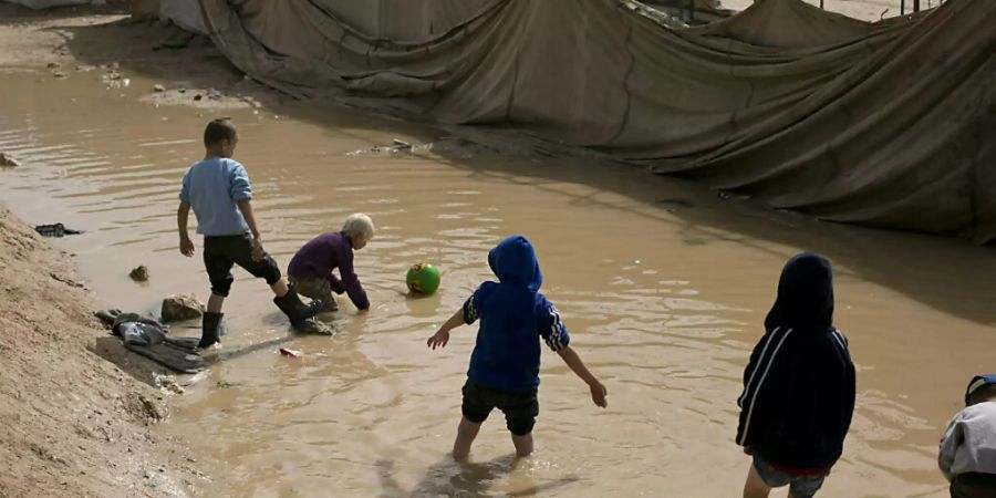 ARCHIV - Kinder spielen in einer Schlammpfütze in der Abteilung für ausländische Familien im Lager Al-Hol in der Provinz Hasakeh. Foto: Maya Alleruzzo/AP/dpa
