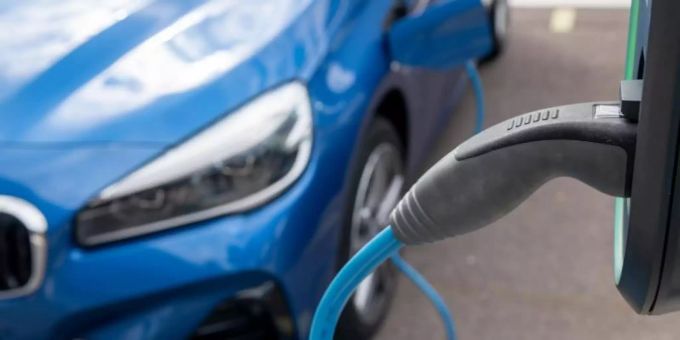Ein Elektroauto lädt auf einem Parkplatz vor dem BMW-Werk in Leipzig. Leaseplan