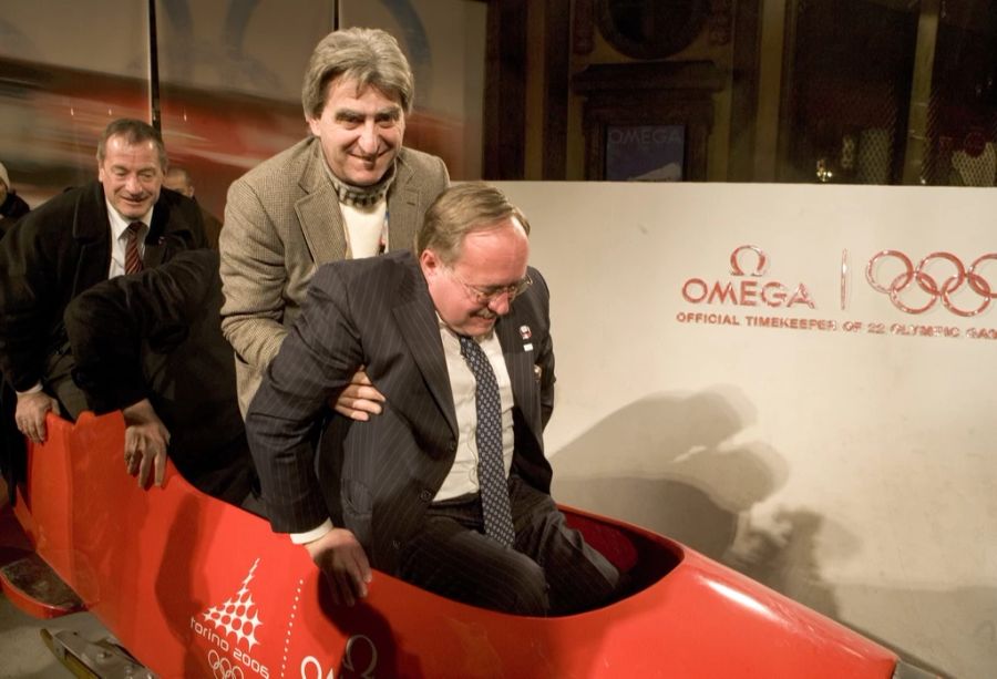 Der CEO der Swatch Group, Nick Hayek, hilft Bundesrat Samuel Schmid in einen von Omega gesponserten Bob im Rahmen der Winterspiele in Turin 2006.