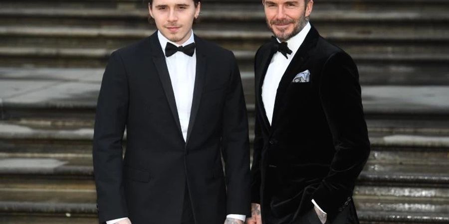 Brooklyn Beckham (l) und sein Vater David teilen offenbar ihre Leidenschaft für Tattoos und Fussball. Foto: Kirsty O'connor/PA Wire/dpa