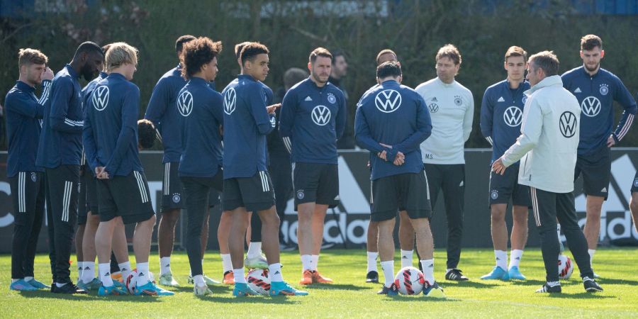 Bundestrainer Hansi Flick (r) wendet sich beim Abschlusstraining an die Spieler der Nationalmannschaft.