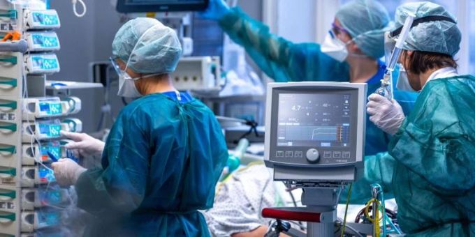 Ärzte und Pflegekräfte betreuen Patienten in einem der Behandlungszimmer einer Intensivstation. pflege