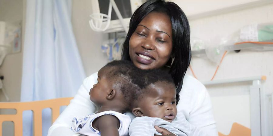 HANDOUT - Ihre Mutter hält die Zwillinge vor der Trennung im April 2019 auf dem Schoss. Italienischen Ärzten ist eine schwierige und seltene Operation zur Trennung von siamesischen Zwillingen gelungen. Foto: Ospedale Pediatrico Bambino Gesù/dpa - ACHTUNG: Nur zur redaktionellen Verwendung im Zusammenhang mit der aktuellen Berichterstattung und nur mit vollständiger Nennung des vorstehenden Credits