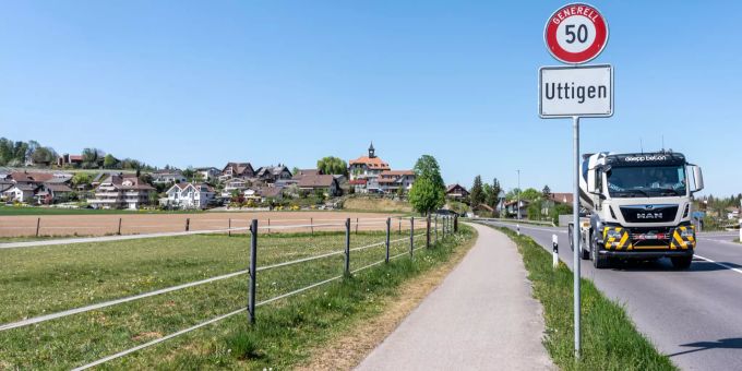 Ortsschild Uttigen mit Blick auf das alte Schulhaus. Ortsschild Uttigen mit Blick auf das alte Schulhaus.