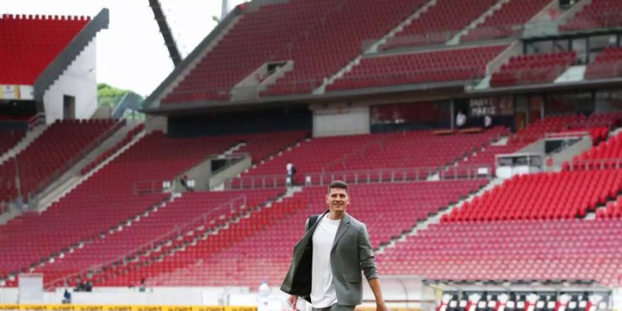 Mario Gomez hat seine Fussballschuhe ausgezogen und verlässt das Spielfeld. Foto: Tom Weller/dpa