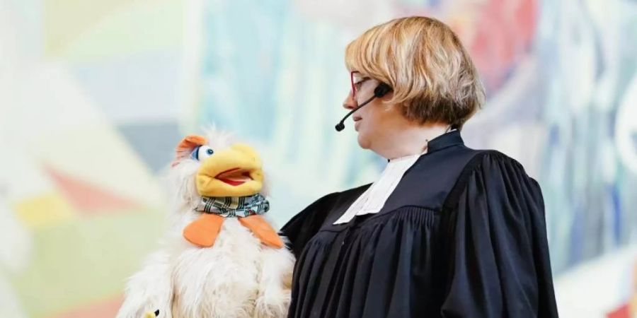 Ungewöhnlicher Dialog auf der Kanzel: Pfarrerin Maibritt Gustrau und Hahn Otto. Foto: Uwe Anspach/dpa
