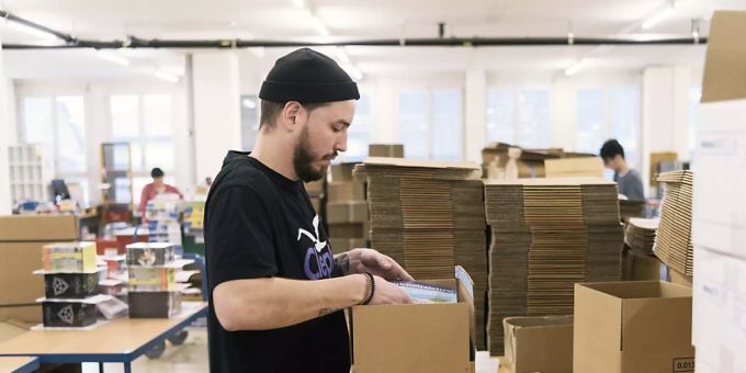 Der Boom im Onlinehandel lässt wieder nach: Ein Mitarbeiter eines Onlinehändlers verpackt ein Päckli (Archivbild). Coronavirus