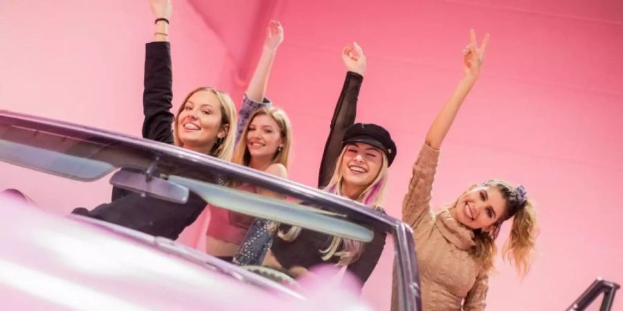 Junge Frauen posieren in einem pinken Cadillac im «Supercandy Pop-Up»-Museum. Foto: Rolf Vennenbernd/dpa