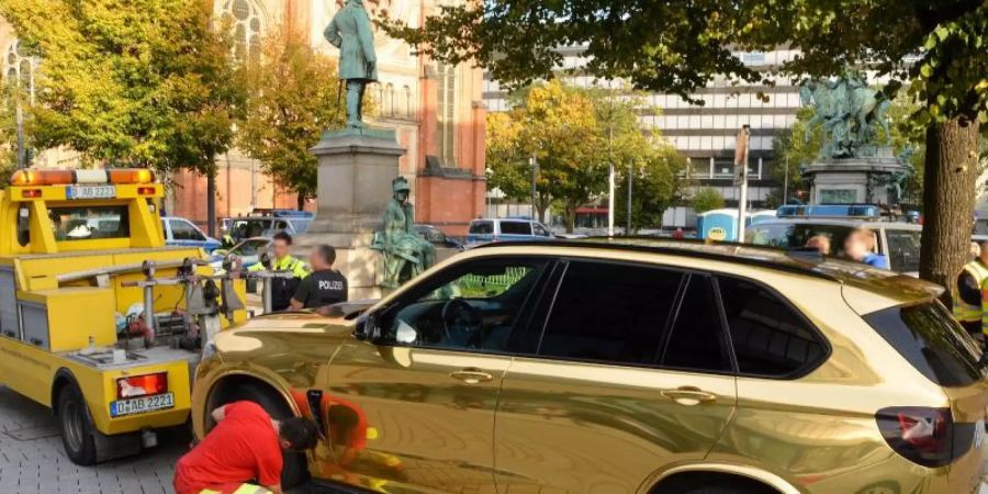 Der goldfarbene SUV wird nahe der Düsseldorfer Königsallee abgeschleppt. Foto: Gerhard Berger
