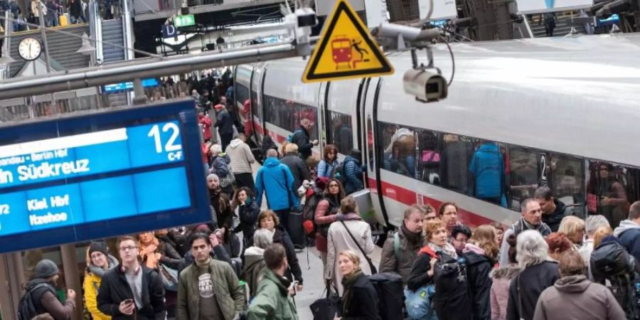 Reisende an einem Bahnhof: Der Grünen-Fraktionschef im Bundestag, Anton Hofreiter, glaubt nicht, dass Bahntickets im Fernverkehr schon Anfang 2020 billiger werden. Foto: Daniel Bockwoldt/dpa/Archivbild