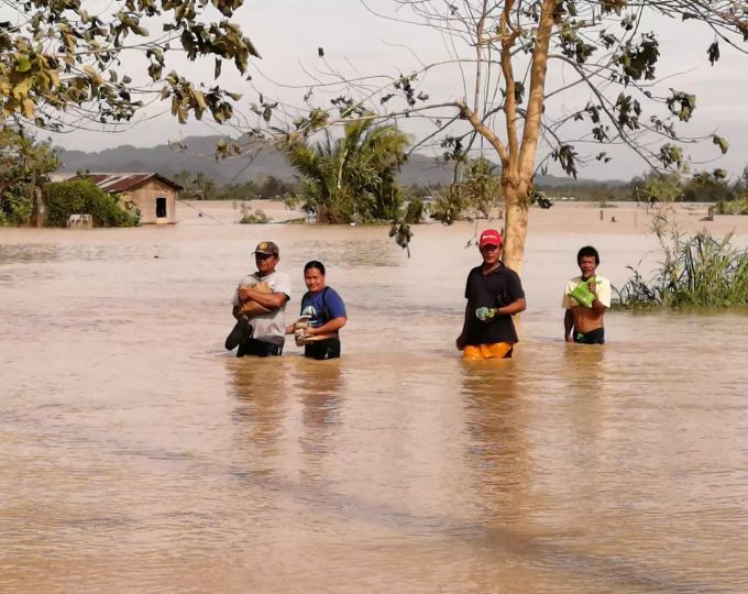 Anwohner waten nach dem Taifun «Phanfone» auf den Philippinen durch Wasser. Philippinen