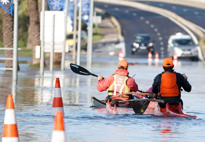 Zwei Männer paddeln mit ihren Kajaks durch die überflutete Strasse in Palavas-les-Flots nach einem nächtlichen Sturm in Südfrankreich. Unwetter in Frankreich