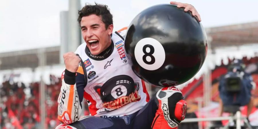 Der Spanier Marc Marquez jubelt nach seinem Sieg mit einer riesigen Billard-Acht. Foto: Sakchai Lalit/AP/dpa