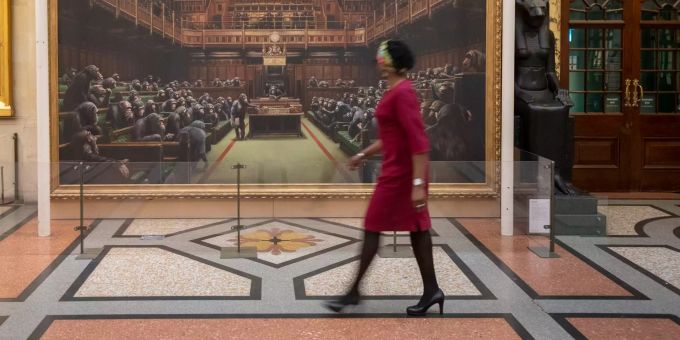 Eine Besucherin geht an dem Schimpansen Gemälde mit dem Titel «Devolved Parliament» des Künstlers Banksy im Bristol Museum vorbei. Schimpansen gemälde