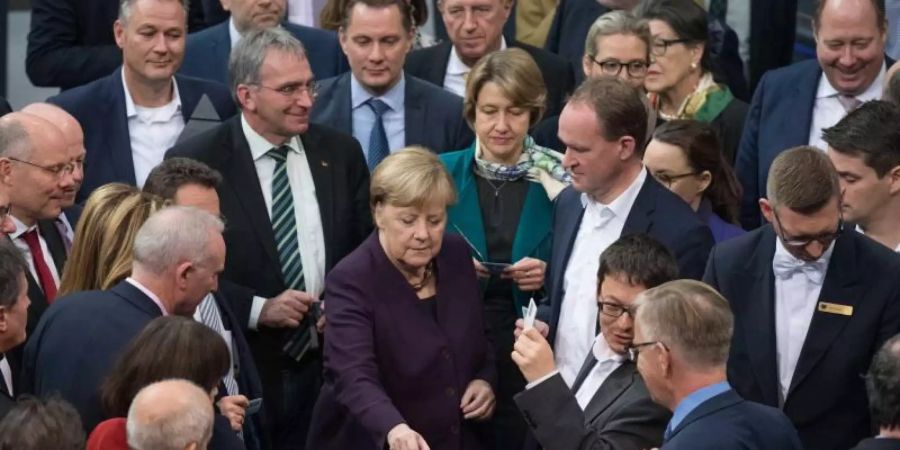 Bundeskanzlerin Angela Merkel (CDU) und weitere Abgeordnete stimmen bei der 128. Sitzung des Deutschen Bundestages namentlich ab. Debattiert wird der Tagesordnungspunkt "Klimaschutz". Foto: Jörg Carstensen/dpa