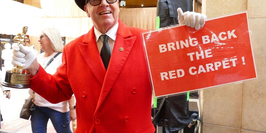 Touristenführer Gregg Donovan hält ein Schild mit der Aufschrift «Bring back the red carpet!» hoch.