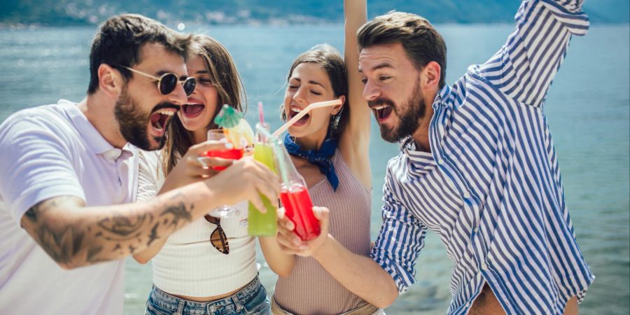 Freunde am Strand trinken Cocktails.