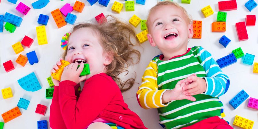 mädchen und junge mit spielzeug, bunt, weisser untergrund