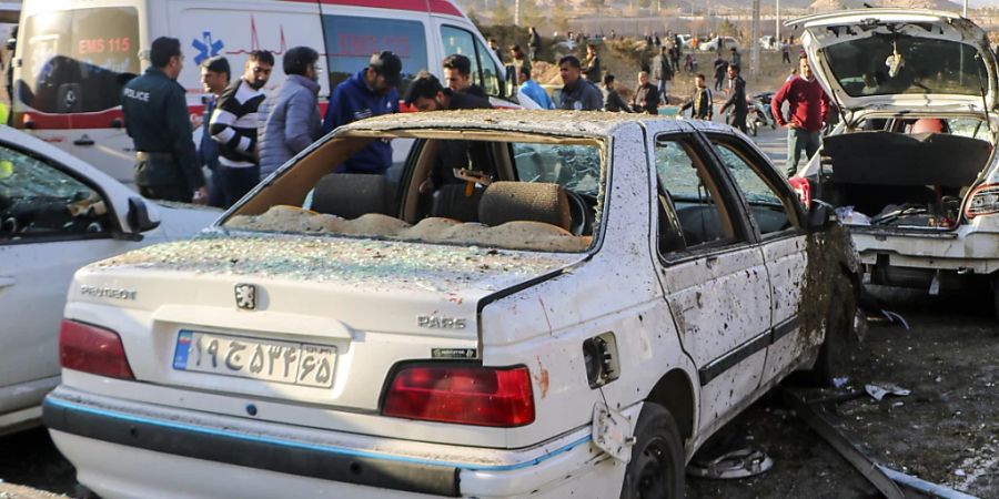 Menschen neben zerstörten Autos nach der Explosion. Foto: Tasnim News Agency/AP/dpa - ACHTUNG: Nur zur redaktionellen Verwendung und nur mit vollständiger Nennung des vorstehenden Credits