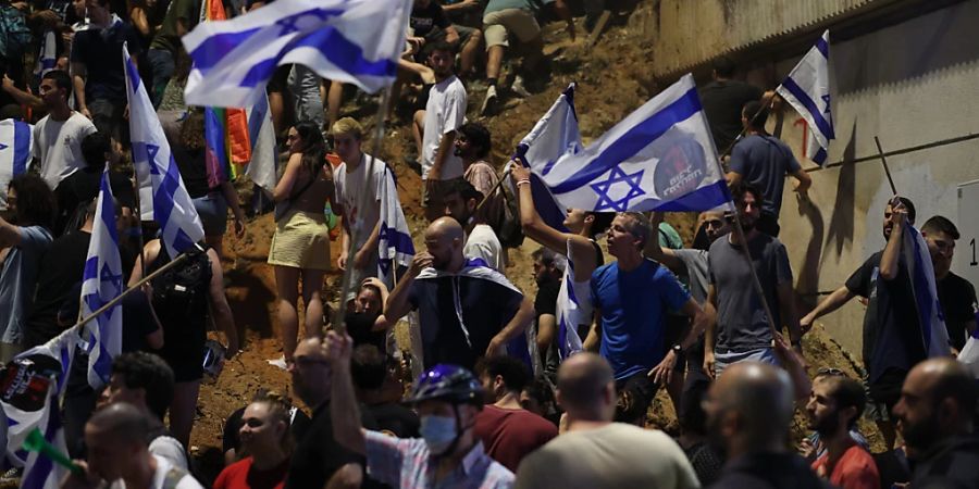 Israelische Demonstranten schwenken Fahnen während eines Protestes gegen die umstrittene Justizreform. Foto: Ilia Yefimovich/dpa