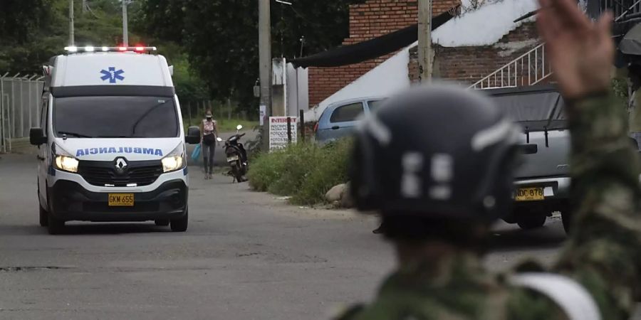 Ein Soldat gibt einem Krankenwagen Signale. Bei einem Anschlag auf einen Militärstützpunkt im Osten Kolumbiens sind dutzende Menschen verletzt worden. Foto: Ferley Ospina/AP/dpa