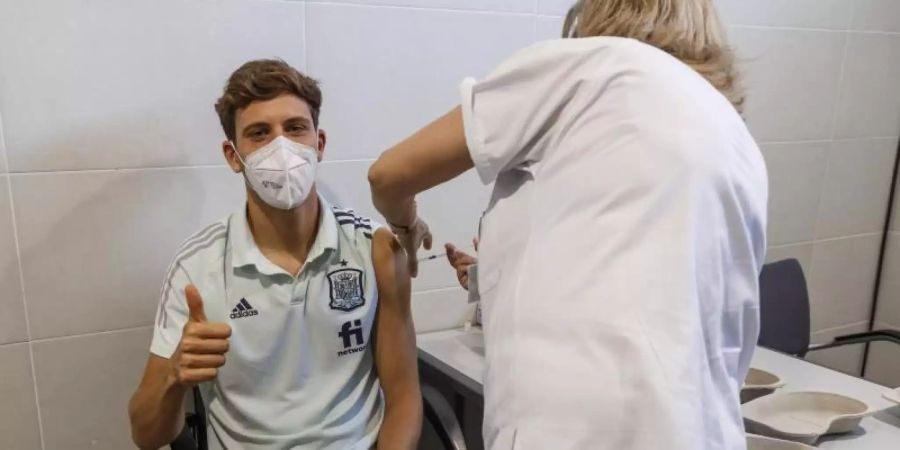 Der spanische Nationalspieler Marcos Llorente wird gegen das Coronavirus geimpft. Foto: Pablo Garcia/RFEF/AP/dpa