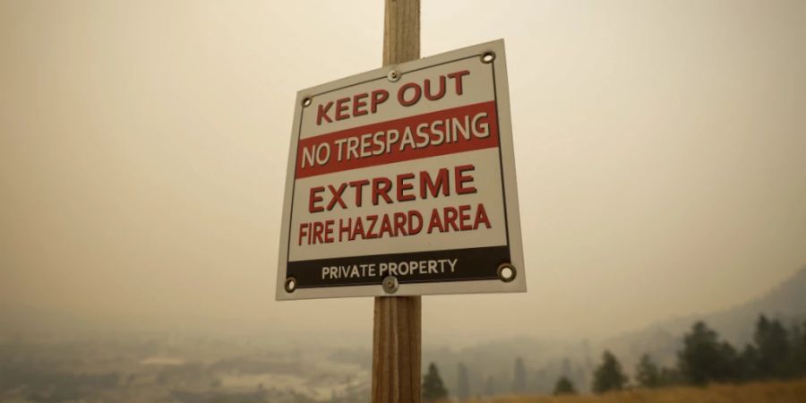 In Kelowna, British Columbia, steht ein Warnschild, das vor der Brandgefahr warnt, während Rauch von Waldbränden die Luft füllt. Foto: Darryl Dyck/The Canadian Press via AP/dpa - ACHTUNG: Nur zur redaktionellen Verwendung und nur mit vollständiger Nennung des vorstehenden Credits