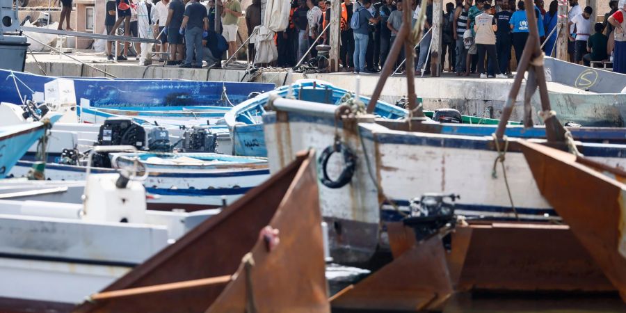 Migranten stehen an einem Hafen auf Lampedusa.