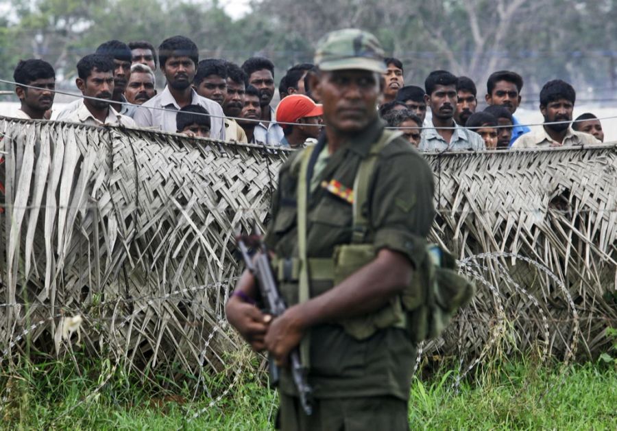 Ein sri-lankischer Armeeangehöriger steht vor einem Lager mit vertriebenen Personen, November 2009.