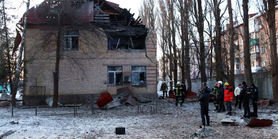 Rettungskräfte stehen in der Nähe eines beschädigten Gebäudes in Kiew.