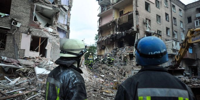 Rettungskräfte im ukrainischen Saporischschja schauen auf die Trümmer eines zerstörten Wohnhauses. saporischschja