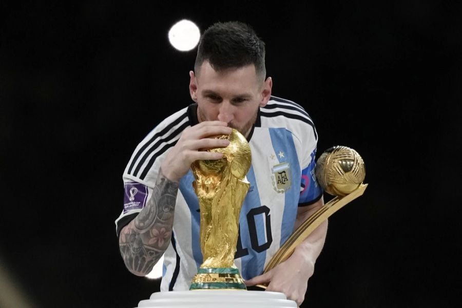 Lionel Messi küsst den WM-Pokal.