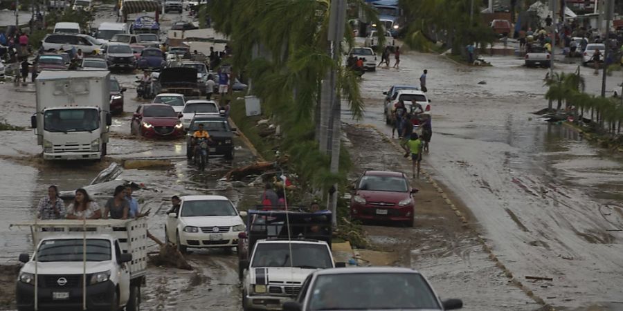 dpatopbilder - Autos überqueren eine überschwemmte Strasse, nachdem Hurrikan Otis über Acapulco, Mexiko, hinweggefegt ist. Foto: Marco Ugarte/AP