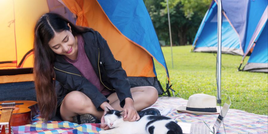 Frau mit Katze beim Camping