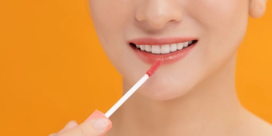 frau trägt lippgloss auf