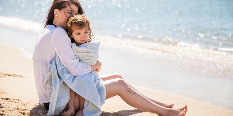 Frau mit Kleinkind am Strand