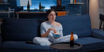 Frau auf Sofa, Fernsehabend, Popcorn