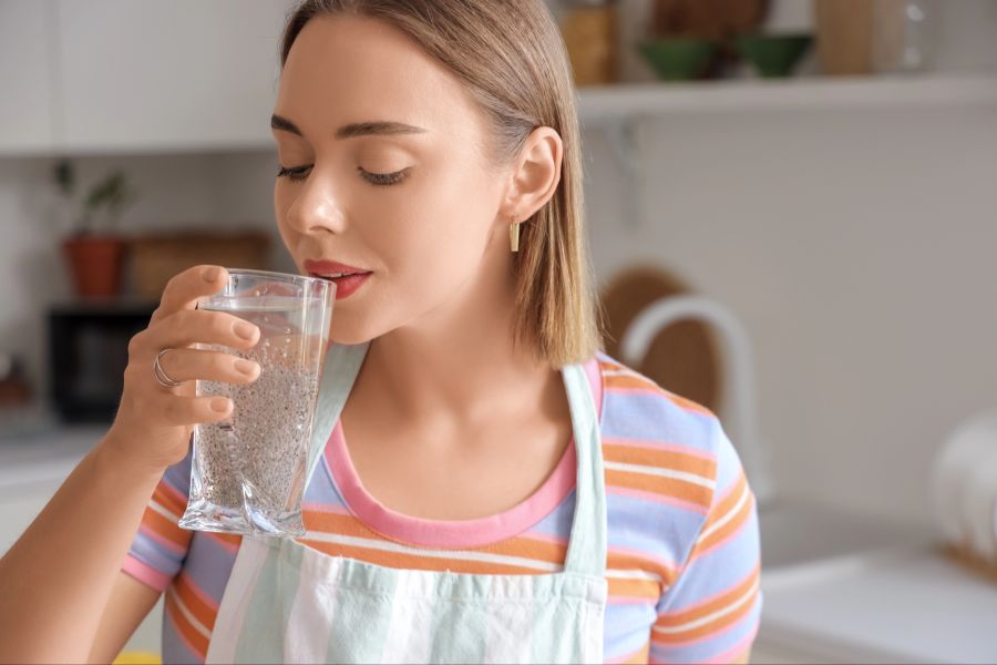 Frau trinkt Wasser mit Chiasamen