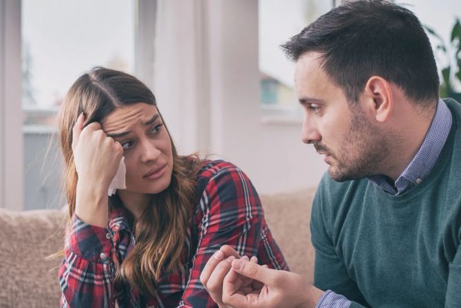 Mann erklärt seiner skeptischen oder traurigen Frau etwas