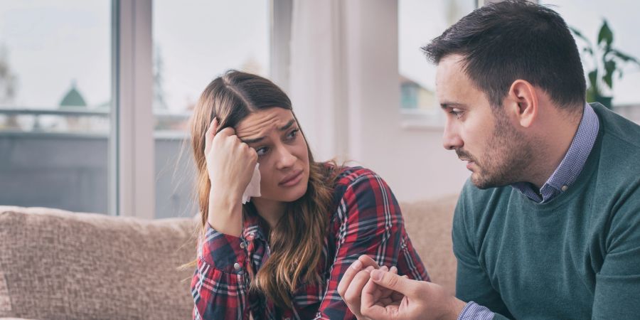 Mann erklärt seiner skeptischen oder traurigen Frau etwas
