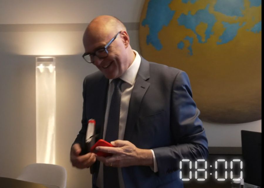Pfister verlässt sein Büro im Bundeshaus mit Unterlagen und Handy unter dem Arm.