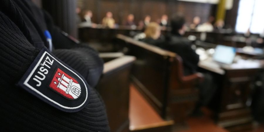 Ein Justizbeamter steht im Sitzungssaal zu Beginn des nicht-öffentlichen Prozesses «White Tiger» vor der Großen Strafkammer 27, einer Jugendkammer, im Strafjustizgebäude. Foto: Marcu...