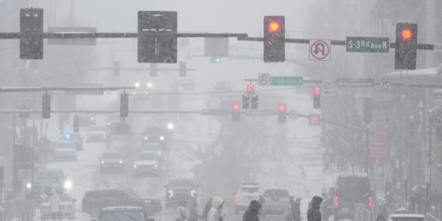 dpatopbilder - Fußgänger überqueren die Straße am Broadway während eines Wintersturms in Nashville. Foto: George Walker IV/AP/dpa