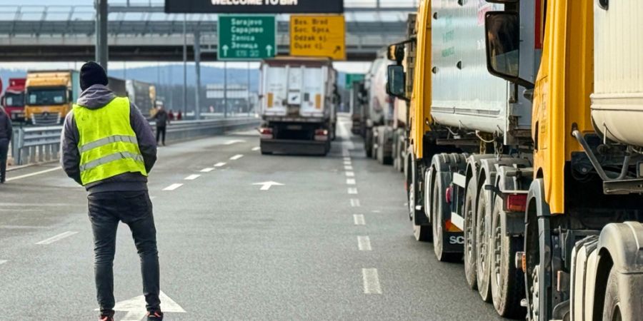 Ein Mann steht neben einer Reihe von Lastwagen und Bussen auf der bosnischen Seite der Grenze zu Kroatien in Svilaj, Bosnien. Foto: Eldar Emric/AP/dpa