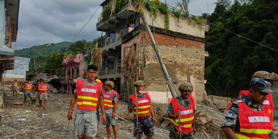Arbeiter räumen nach einer Sturzflut im Gebiet Devighat im Distrikt Nuwakot Trümmer weg. Foto: Rajesh Kumar Singh/AP/dpa